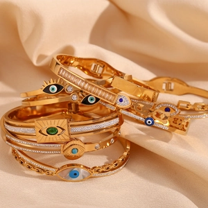 Macro shot of 18K gold plated evil eye bracelets with zircon on soft beige fabric