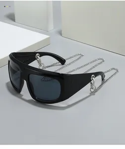 Detail of oversized black Y2K sunglasses with decorative thick silver metal chain