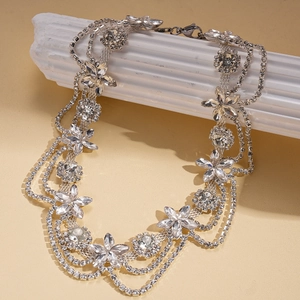 Luxurious silver layered necklace with sparkling diamond flower charms on white stone