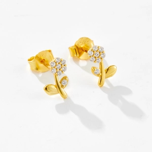 Macro detail of S925 sterling silver stamp on golden flower earrings with zircon stones