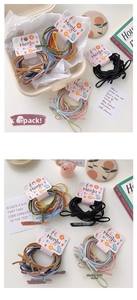 Close-up of colorful elastic hair ties on decorative pink cards in a cozy setting