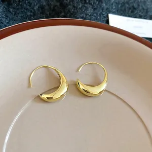 Polished 14k gold plated geometric oval hoop earrings on elegant ceramic display tray