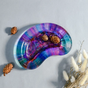 Detalle de una bandeja de resina en forma de riñón con texturas de arte fluido violeta y azul