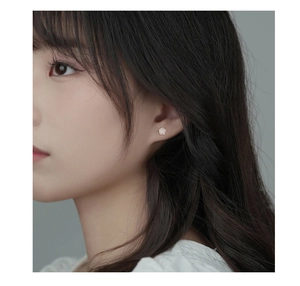 Close-up of a model wearing elegant S925 silver white rose flower stud earrings