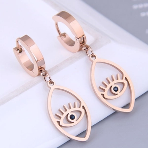Detail of rose gold evil eye huggie earrings featuring blue zircon and lash design