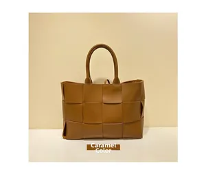 Detailed view of caramel leather woven tote bag featuring wide-stripe weaving technique