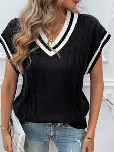 Detailed cable knit pattern and white striped trim on the V-neck black sweater vest