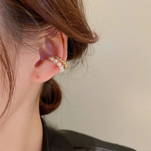 Double-layered gold twist and pearl ear cuff earring shown on model in a detailed side view