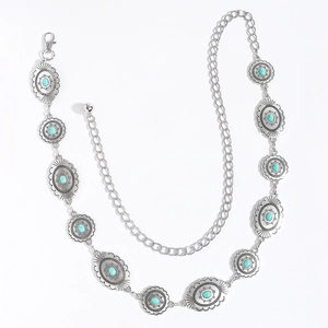 Detailed macro view of silver metal chain belt featuring oval turquoise stone settings