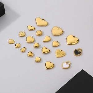 Detailed flat lay of assorted golden stainless steel heart charms with enamel finishes