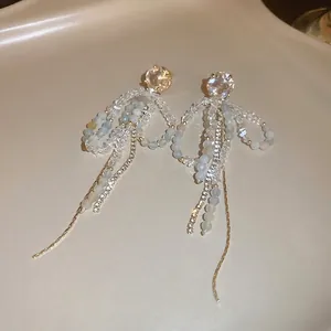 Elegant bowknot drop earrings with blue crystals and long gold tassels for women