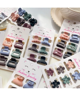Detailed view of assorted mini matte hair claws in floral and geometric shapes on a card
