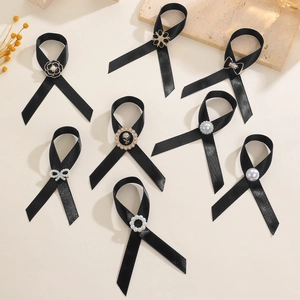 Vue détaillée de huit broches en satin noir avec perles et détails de fleurs en métal
