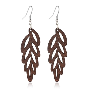 Detailed view of dark brown leaf-shaped wooden earrings with metal hooks on white surface