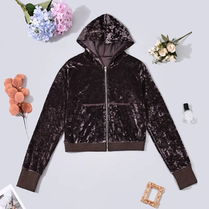 Detail of brown velvet zip-up hoodie with ribbed cuffs and decorative lifestyle props