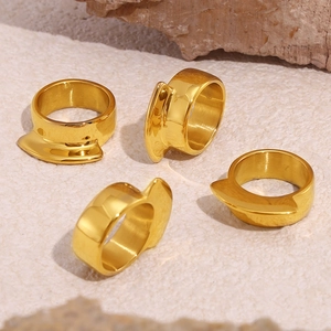 Set of four geometric 18k gold plated stainless steel rings on a minimalist stone surface