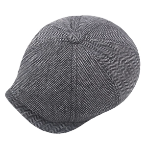 Close-up of gray herringbone newsboy cap showing tweed texture and top button detail