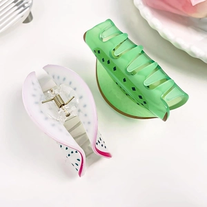 Detail of cute kiwi and dragon fruit hair claws showing resin texture and metal springs
