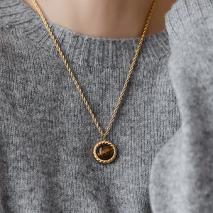 Vintage gold twist chain necklace with a round tiger eye stone pendant on grey sweater