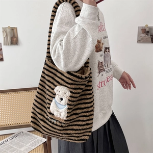 Detail showing the plush striped tote bag featuring a cute white puppy embroidery patch