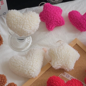 Close-up of heart and star sherpa plush charms with soft sherpa texture and hanging loops