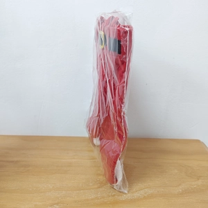 Detailed view of red Christmas pant-shaped wine bottle bag in clear protective packaging