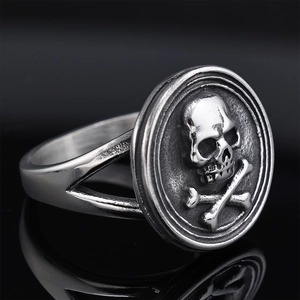 Retro punk skull and crossbones signet ring with vintage silver finish on black base