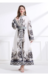 Détail d'une robe caftan blanche à fleurs Paisley avec col montant et ceinture taille