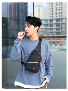 Detail of black sports crossbody bag with headphone port and adjustable shoulder strap