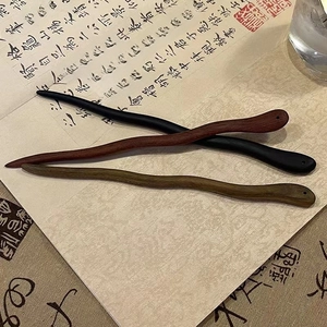 Gros plan de pics à cheveux ondulés en bois de santal en trois couleurs sur papier calligraphie
