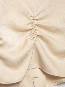 Vue macro du tissu froncé champagne avec un fini satiné lisse et texture élégante