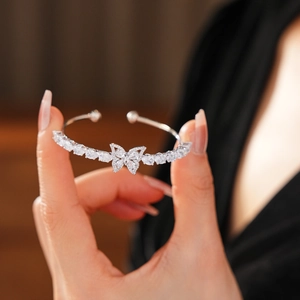 Détail d'un bracelet ouvert argenté orné d'un motif papillon serti de zircons
