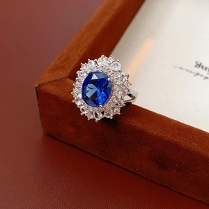 Dettaglio di un anello vintage in argento con gemma blu ovale e corona di diamanti bianchi