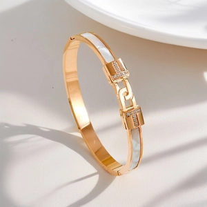 Macro shot of rose gold bangle featuring white mother-of-pearl inlay and sparkling pavé diamonds