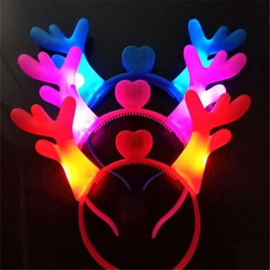 Detail of LED glowing reindeer antlers headbands with heart ornament in three colors