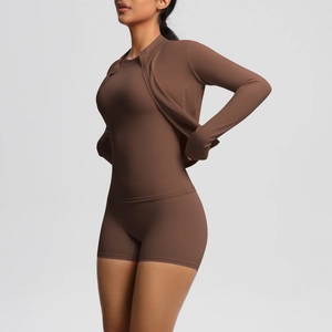 Three-piece yoga set detail showing high-waist shorts and a slim-fit jacket in dark brown
