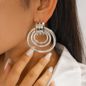 Close-up of geometric multi-layered silver hoop earrings worn on a female model