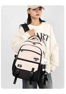 Student backpack detail showing black and white contrast design with plush cloud charm