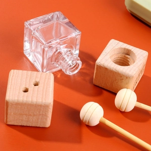 Close-up of square glass car perfume bottle with wooden caps and diffuser sticks