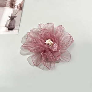 Détail d'une pince à cheveux rose en organza faite main avec une texture élégante