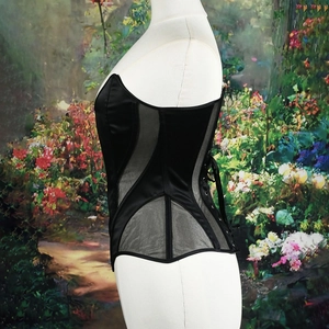 Side view of black corset top featuring satin panels, mesh inserts and lace-up back