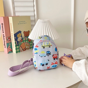 Detail of light blue kids sling bag featuring cartoon vehicle prints and purple strap