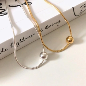 Macro detail of minimalist S925 sterling silver snake bone bracelet with polished round beads