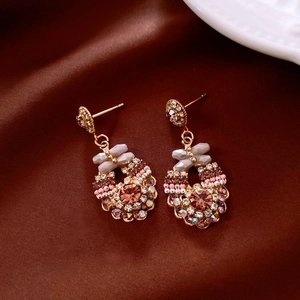 Macro shot of vintage style earrings with colorful rhinestones and gold alloy base