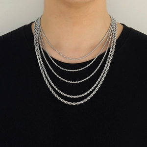 Detail showing five layered silver twisted rope chains on a model wearing black t-shirt