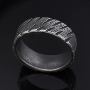 Industrial style vintage stainless steel ring with rustic bark texture on black background