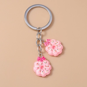 Detail of pink donut keychains with colorful sprinkles and decorative bows on silver rings