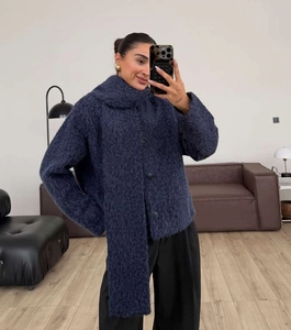Close-up of deep blue plush knit texture and round button details on women's jacket