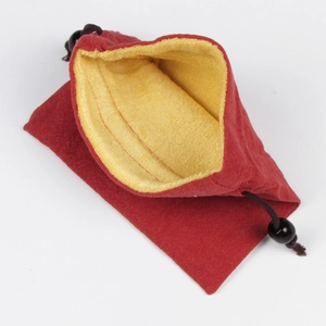 Dettaglio macro del sacchetto per gioielli in velluto rosso con fodera gialla e perle
