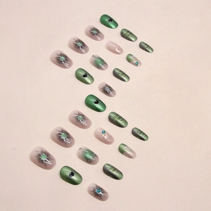 Green cat-eye press-on nails with starburst patterns and heart accents, set of 24